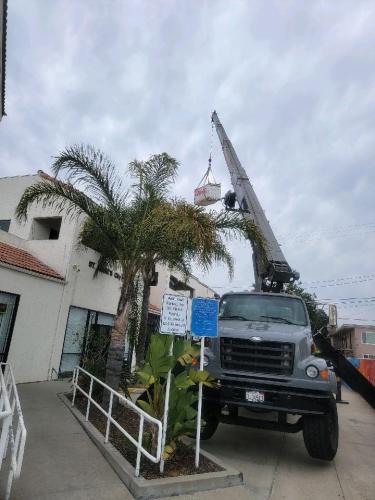 Crane hoists roofing supplies.